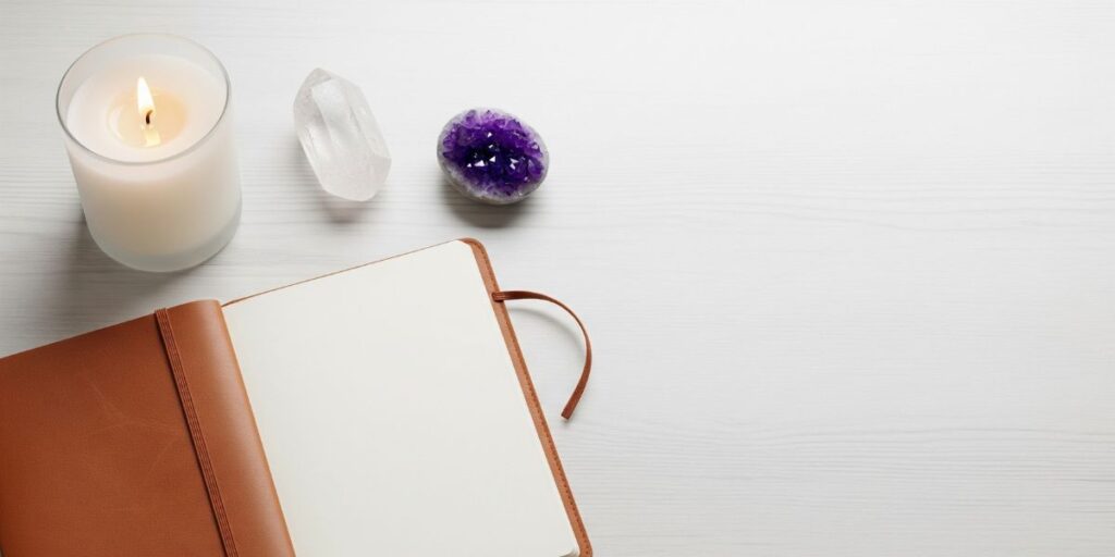 Healing space at home with journal, candle, balm, and crystals.
