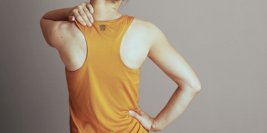 Hands supporting the neck and shoulders to ease stiffness after returning to work in January