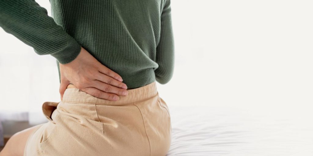 person holding lower back where pain keeps returning
